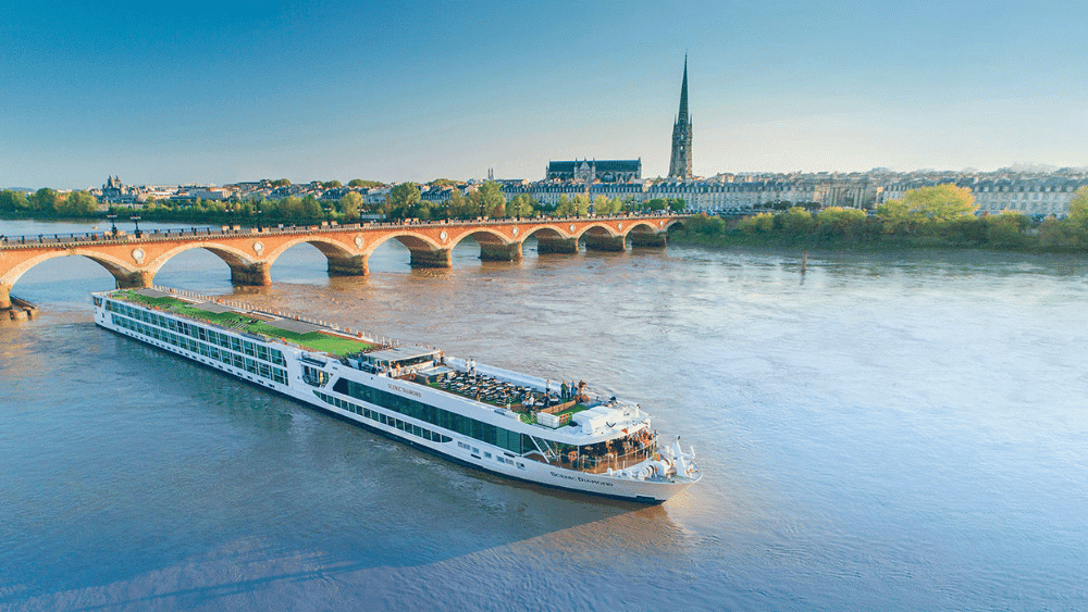A luxury river boat gliding down a serene river, showcasing Europe's hidden gems along the picturesque banks.